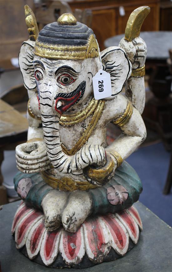 A large painted Balinese wooden kris stand modelled as a seated Ganesh, 20th century, height 51cm